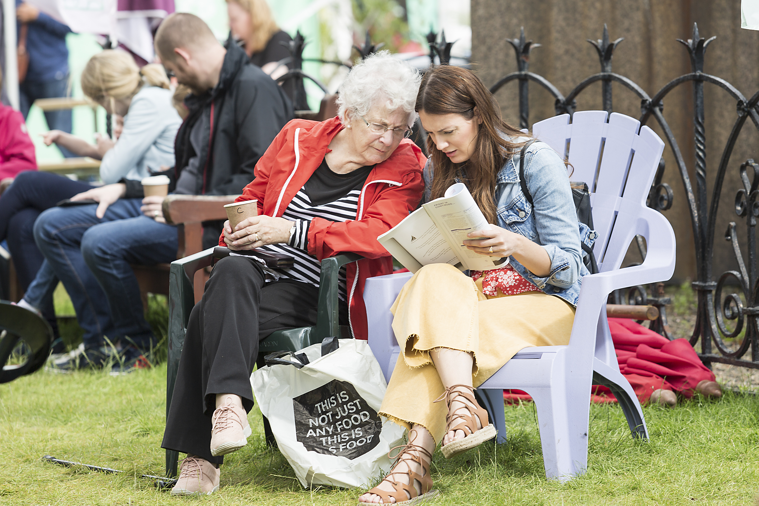 Two generations of women reading a Book Festival brochure