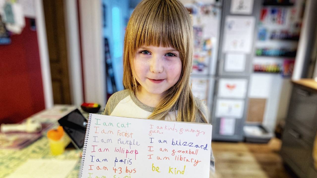 Image of child holding up their Self Portrait Poem